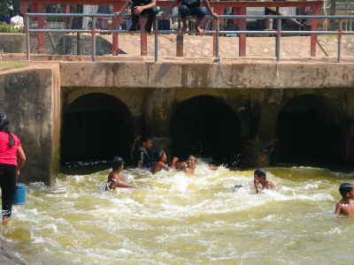 Kinder baden und spielen im Abwasser
